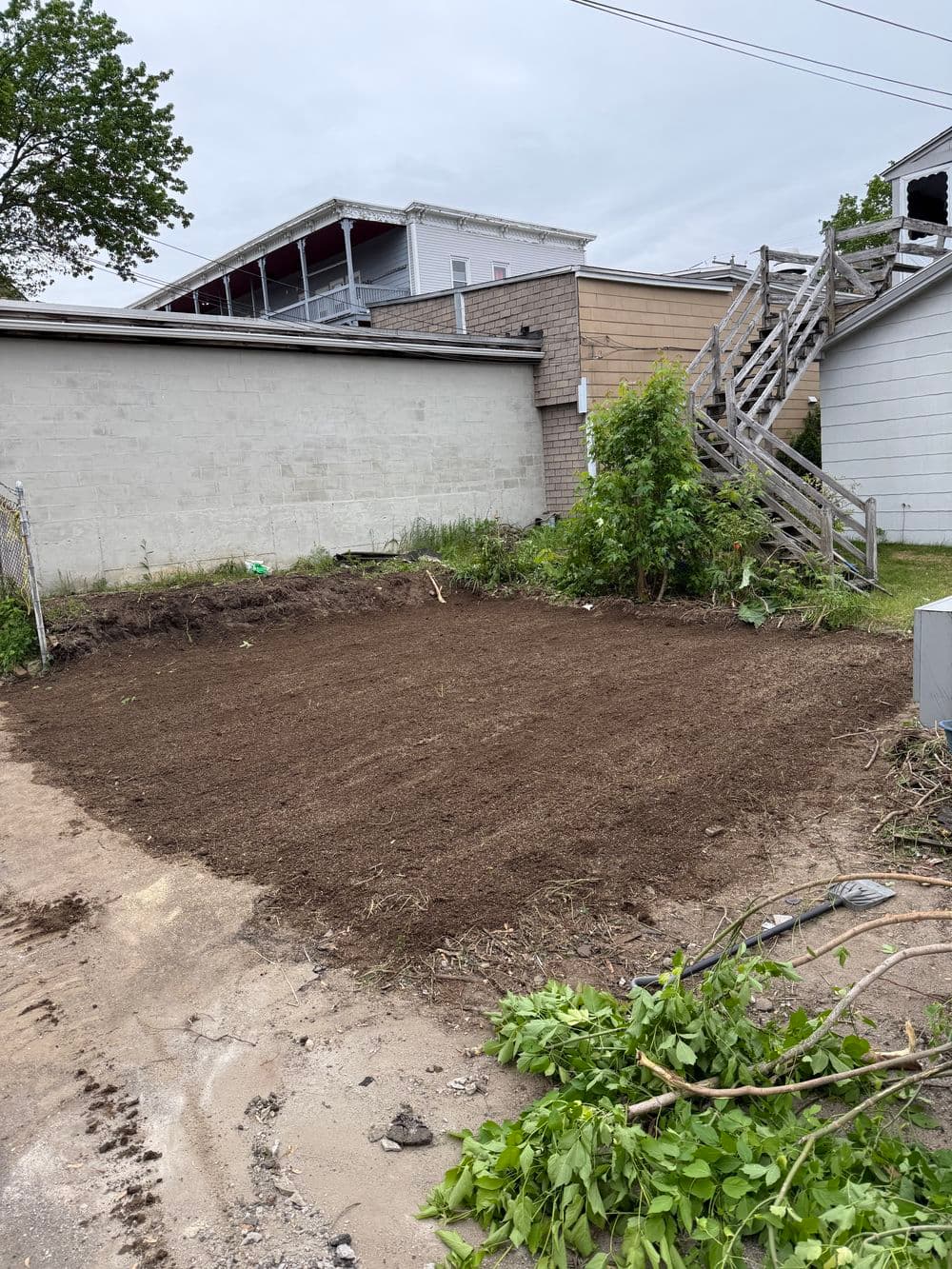 Cleared soil area in urban setting, ready for landscaping or construction projects.